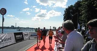 Das Team beim gemeinsamen Lauf über den roten Teppich durchs Ziel